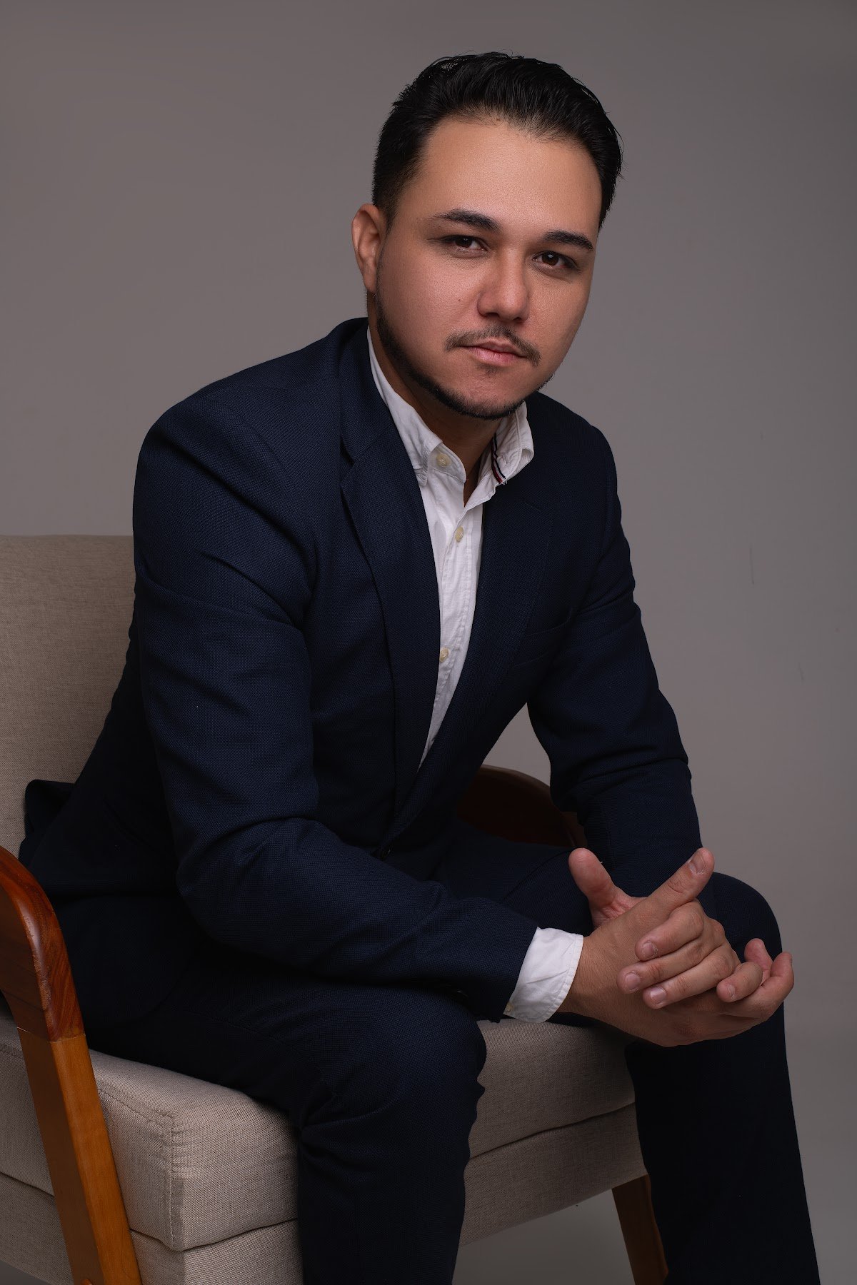 Pablo Paiva sentado em poltrona, em ensaio profissional